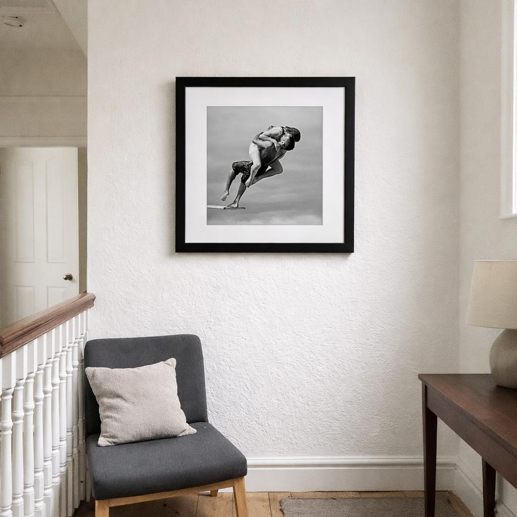 Passionate Diving Embrace by Tatyana Druz. Classic Oak framed print hanging in a hallway, from TheArtFolio